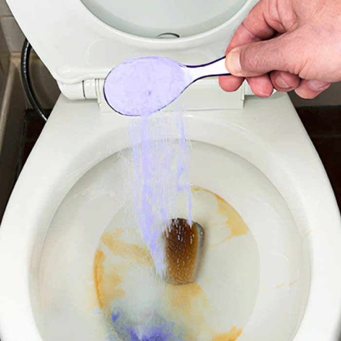 FizzClean Pulver wird in eine verschmutzte Toilette gegeben